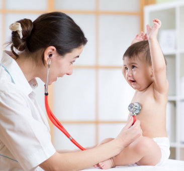 female pediatrician checking little child using stethoscope