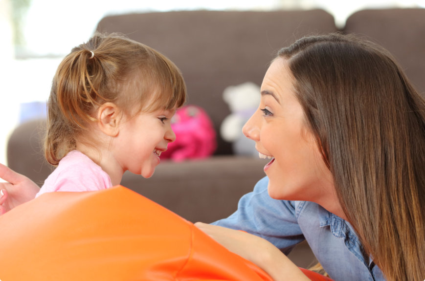 woman and female child smiling at each other