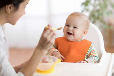 mother feeding her baby son with fruit puree