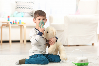 little boy using nebulizer at home