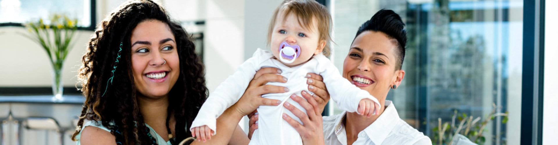 two women carrying little child